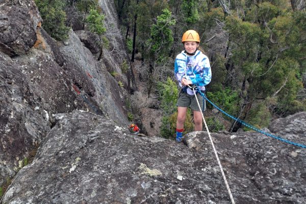 Indoor Climb South Coast: young girl starts the cliff descent on an abseilling lesson near Nowra.